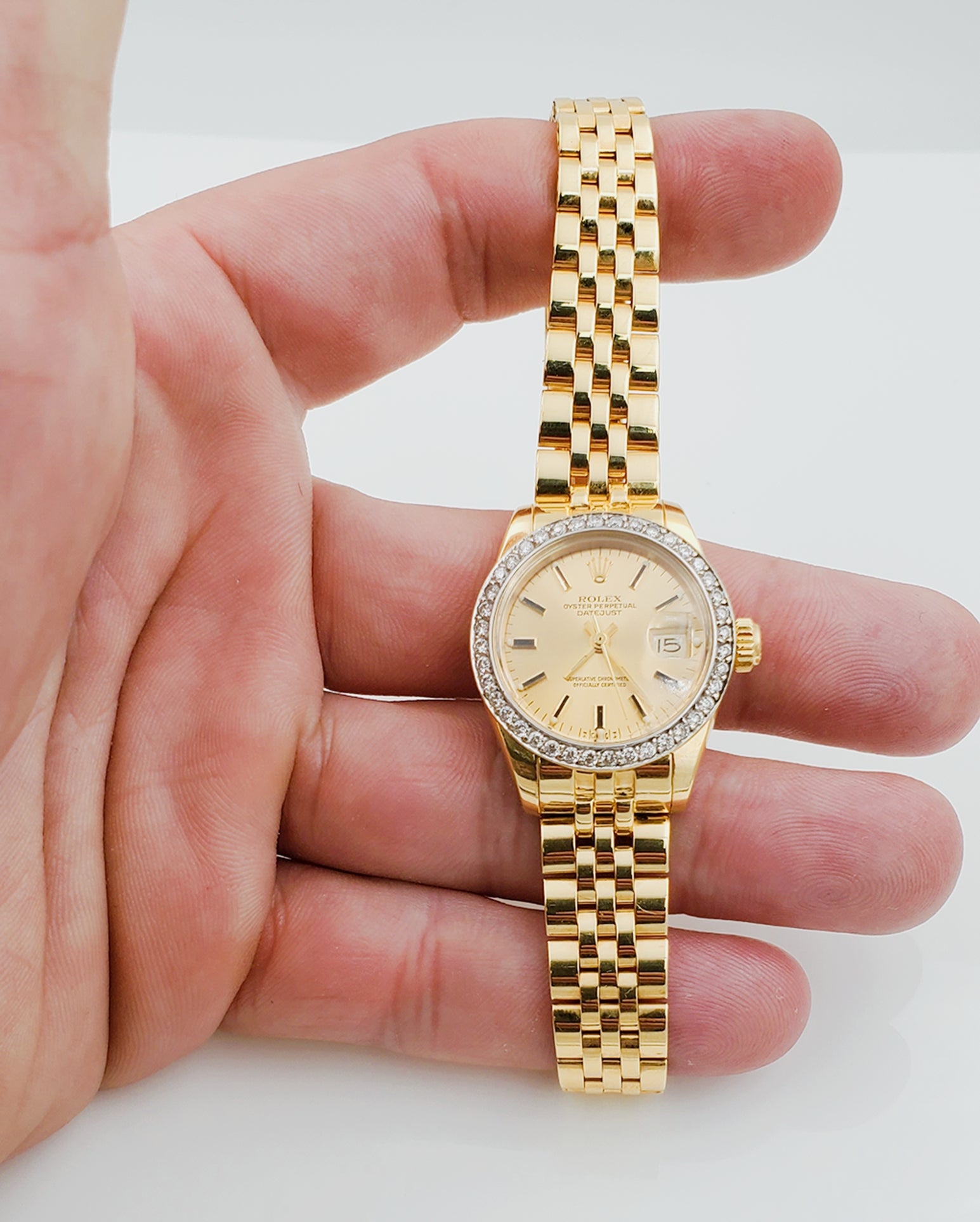 Ladies Rolex 26mm DateJust 18K Yellow Gold Watch with Champagne Dial and Custom Diamond Bezel. (Pre-Owned)