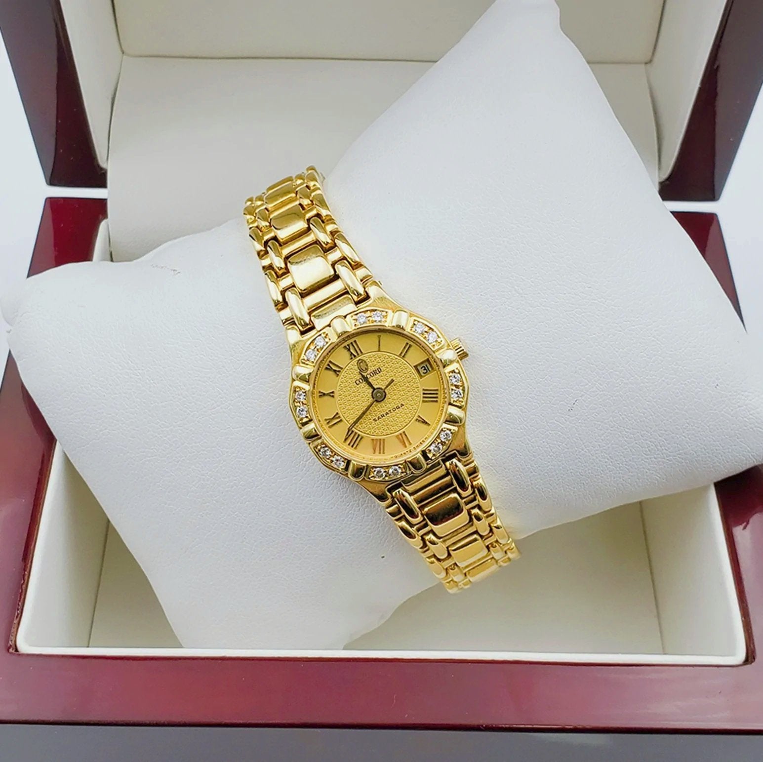 Ladies Concord Sarento 24mm Solid 18K Yellow Gold Band Watch with Roman Numeral Gold Dial and Diamond Bezel. (Pre-Owned)