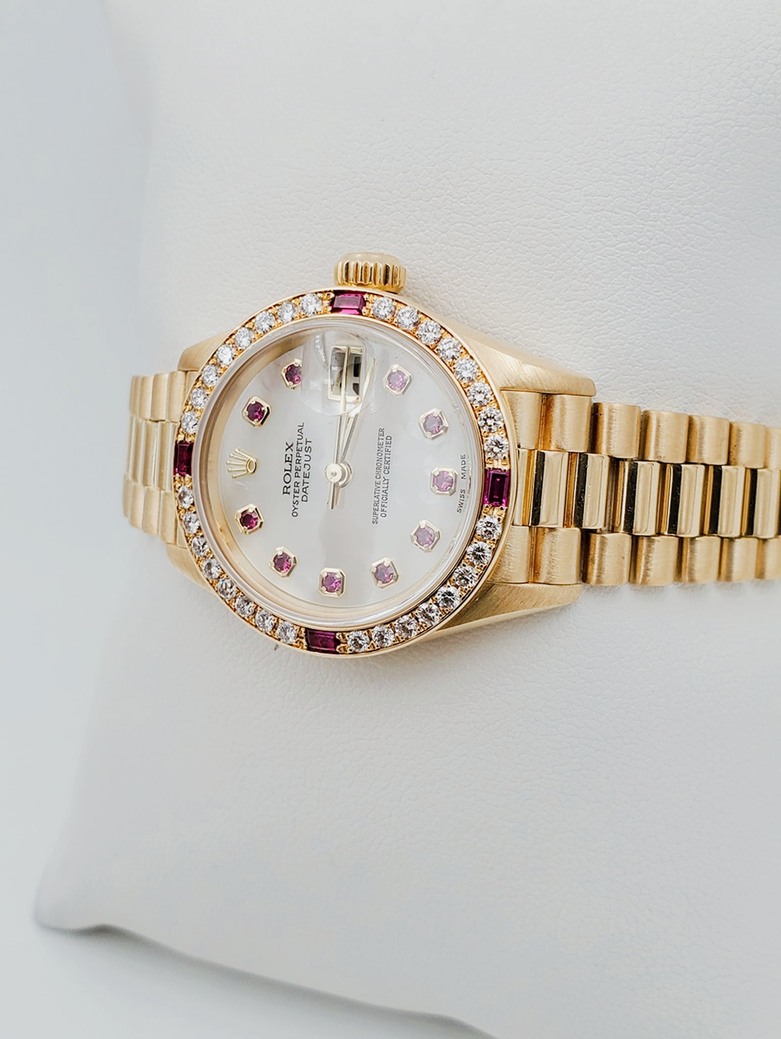 Ladies Rolex Presidential 26mm Solid 18K Yellow Gold Watch with Mother of Pearl Ruby Dial and Diamond Bezel. (Pre-Owned 7906B)