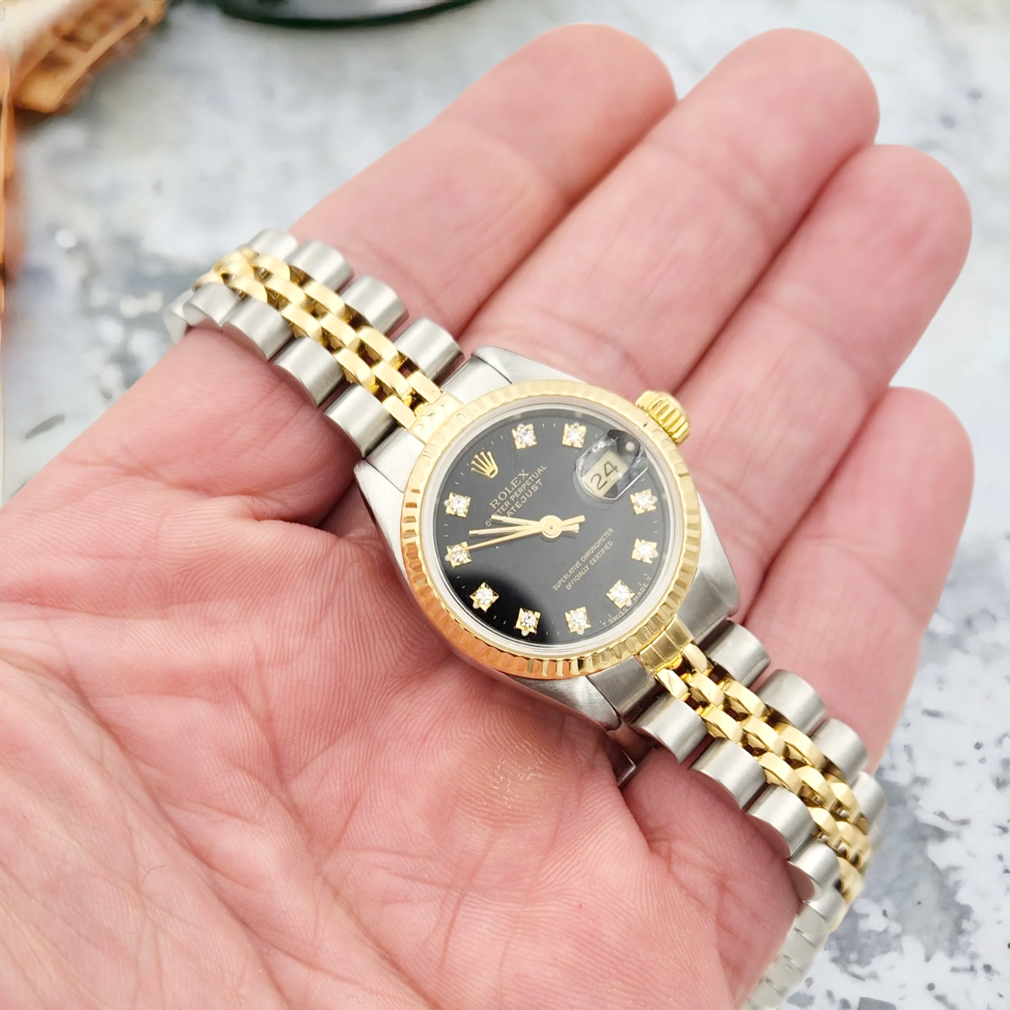 Ladies Rolex 26mm DateJust Two Tone 18K Yellow Gold / Stainless Steel Watch with Black Diamond Dial and Fluted Bezel. (Pre-Owned)